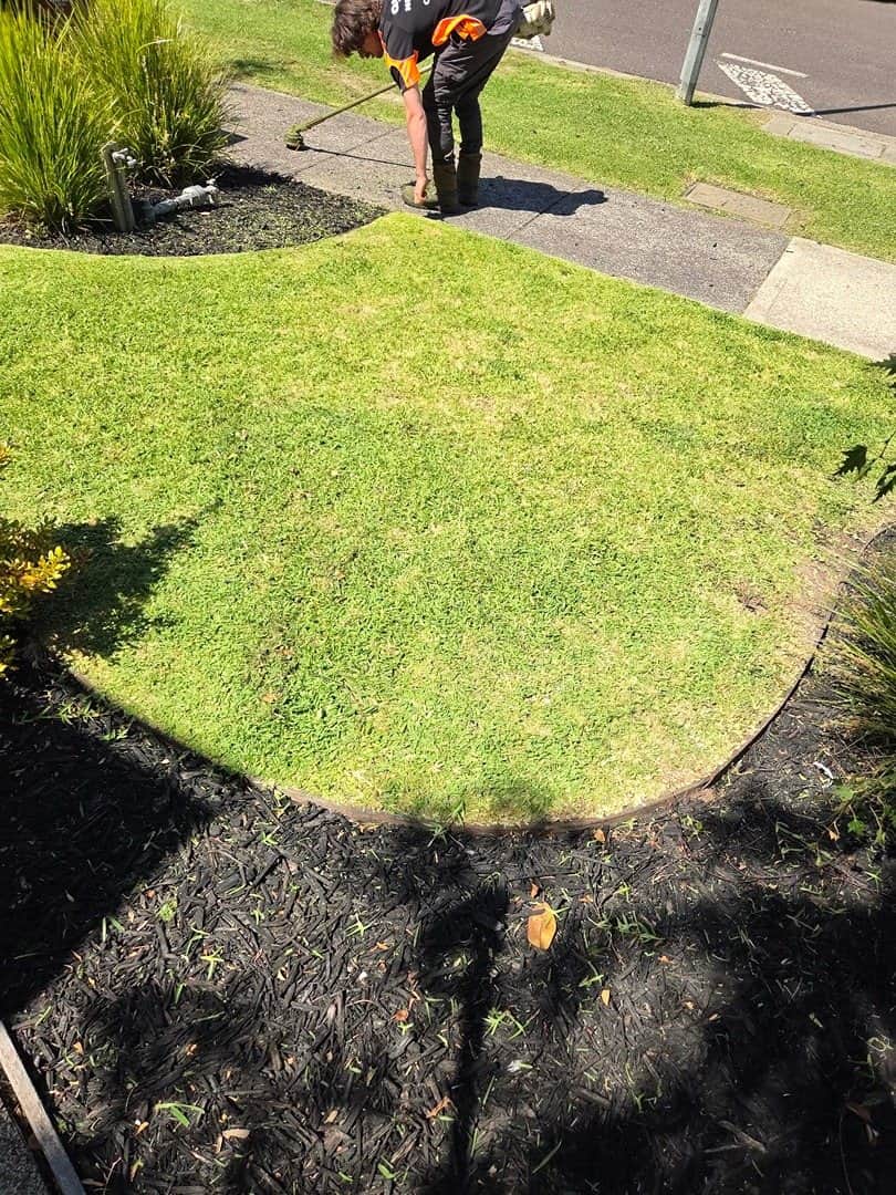 Terra Maintenance crew member edging a garden bed with professional equipment in Narre Warren